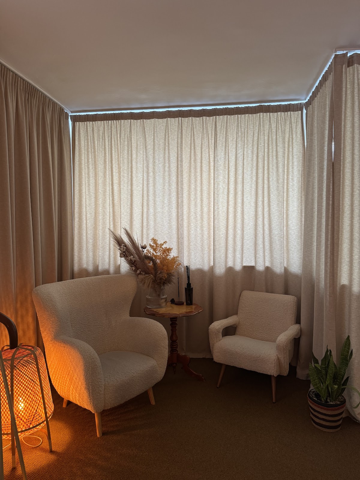 Kącik relaksu z fotelami boucle i świecą w gabinecie o.massage.warsaw